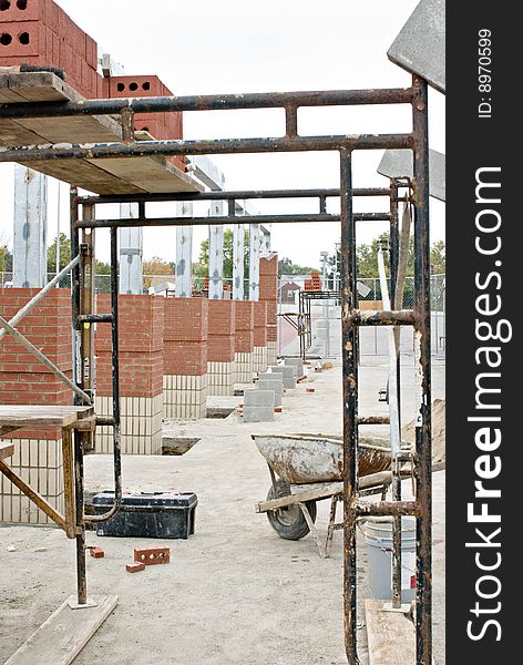 General construction site with scaffolding and brick columns.