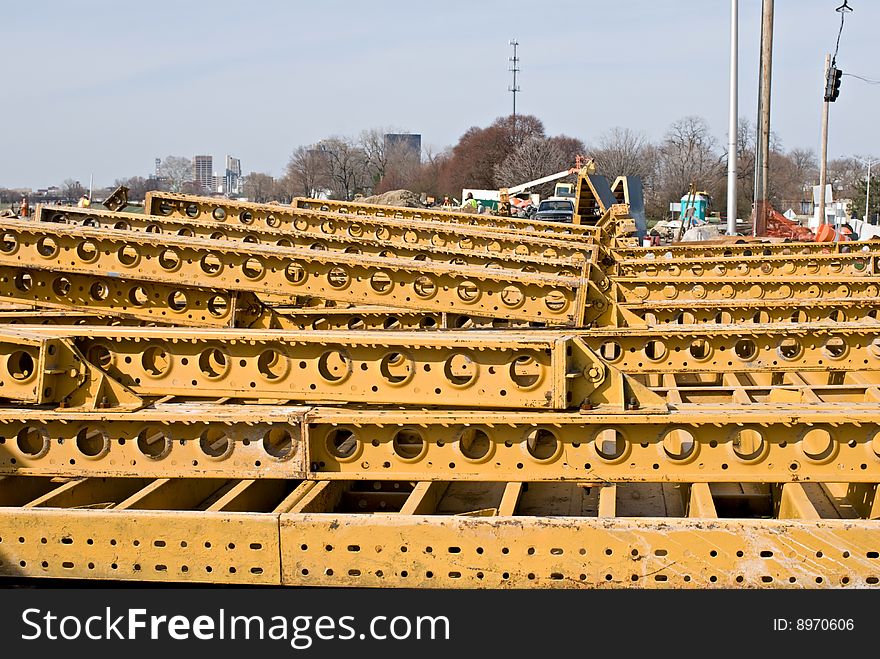 Supply of yellow steel girders piled up at construction site. Supply of yellow steel girders piled up at construction site.