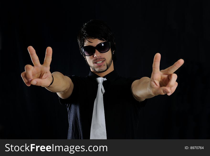 Portrait of young trendy businessman with cool gesture over black background. Portrait of young trendy businessman with cool gesture over black background