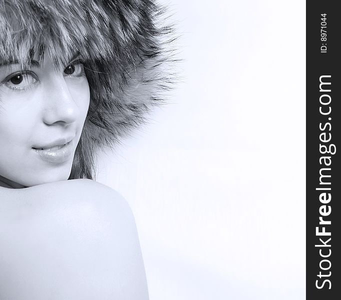 It is black - a white portrait of the beautiful girl in a fur cap close up. It is black - a white portrait of the beautiful girl in a fur cap close up.