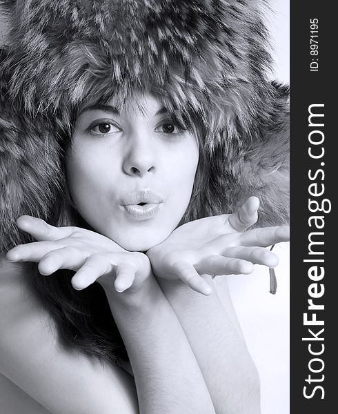 It is black - a white portrait of the beautiful girl in a fur cap close up. It is black - a white portrait of the beautiful girl in a fur cap close up.