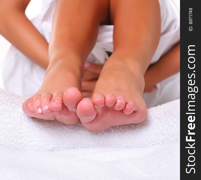 Feet and SPA Well-groomed fingers of female feet on a white towel