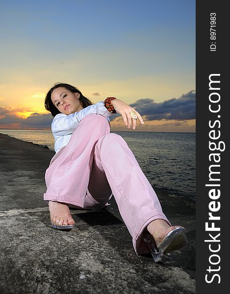 Portrait of young trendy fashion model posing against sunset sky background. Portrait of young trendy fashion model posing against sunset sky background