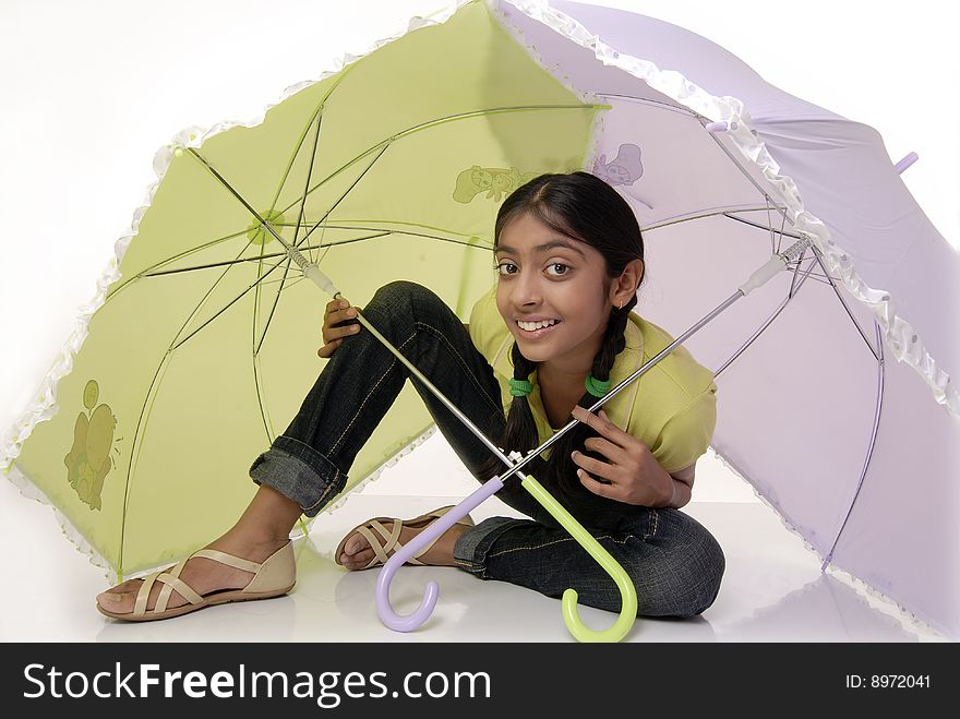 Girl protecting herself under green and purple umbrella. Girl protecting herself under green and purple umbrella