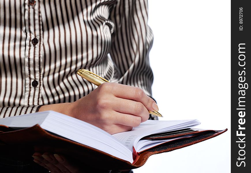 The woman does records by a pen in a notebook