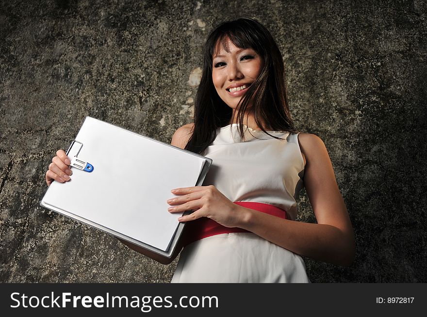 Beautiful Asian Woman Showing blank paper on clipboard. Beautiful Asian Woman Showing blank paper on clipboard.