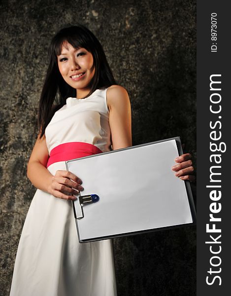 Beautiful Asian woman showing a clipboard and blank empty paper. Beautiful Asian woman showing a clipboard and blank empty paper.