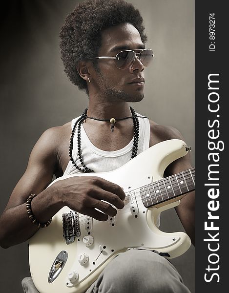 Portrait of young african man playing electric guitar