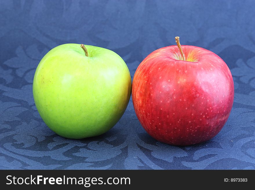 Green and red apples on blue background