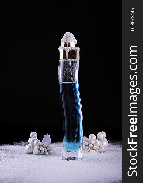 Tall perfume bottle with blue liquid in studio lighting