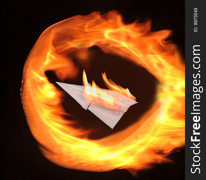 Burning paper airplane on a black background