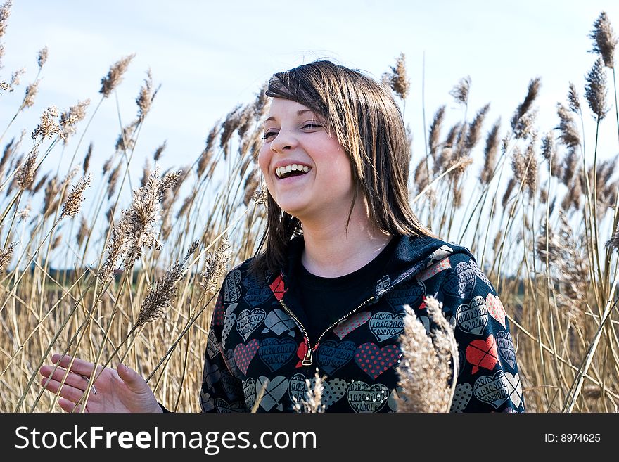 Young girl amongst pampas grass in field on a sunny day. Young girl amongst pampas grass in field on a sunny day