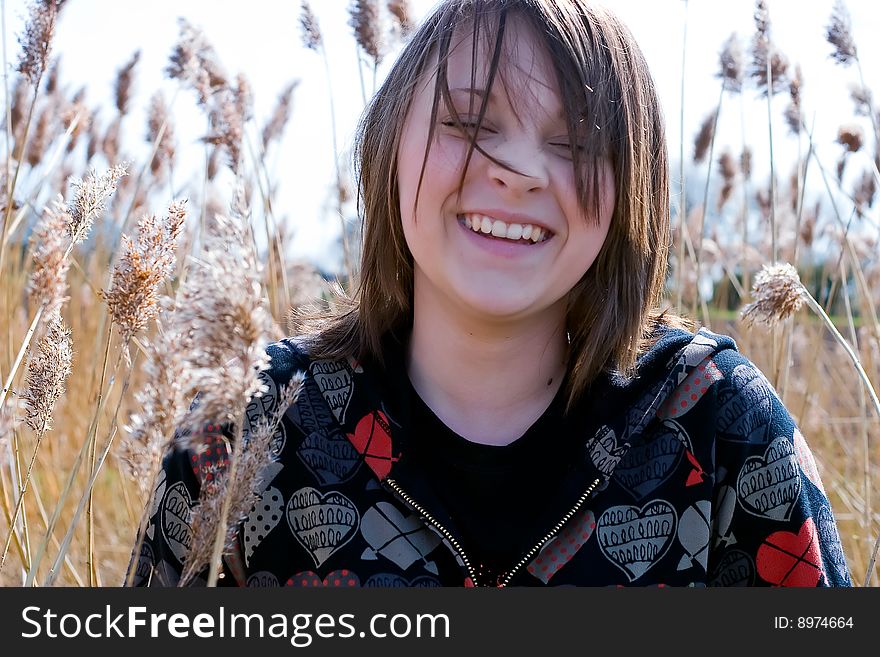 Young girl amongst pampas grass in field on a sunny day. Young girl amongst pampas grass in field on a sunny day