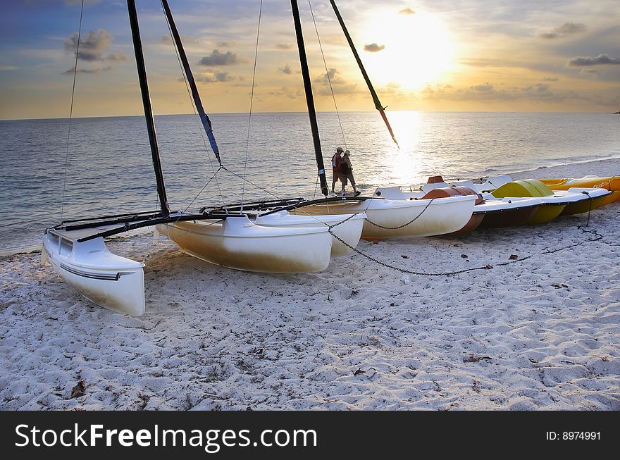 View of tropical beach at sunset with sailing boats on the sand. View of tropical beach at sunset with sailing boats on the sand