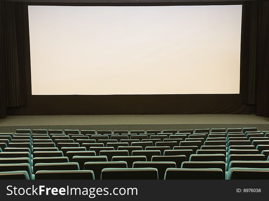 Empty cinema auditorium with line of green chairs and silver screen. Ready for adding your own picture. Empty cinema auditorium with line of green chairs and silver screen. Ready for adding your own picture.