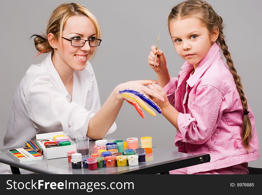 Little girl playing with mom, painting her fingers. Little girl playing with mom, painting her fingers