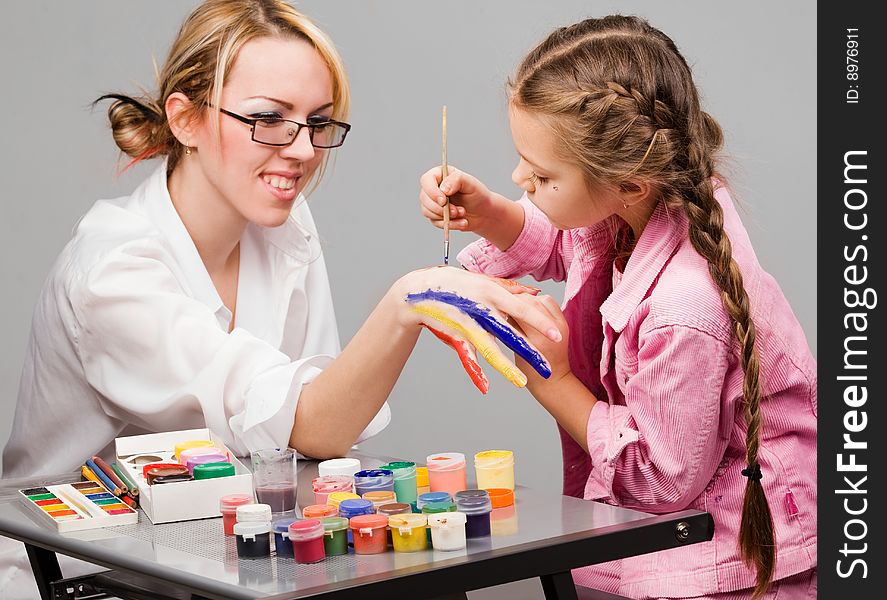 Little girl playing with mom, painting her fingers. Little girl playing with mom, painting her fingers