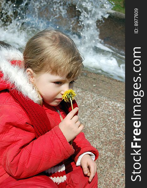 Little girl smelling a flower spring