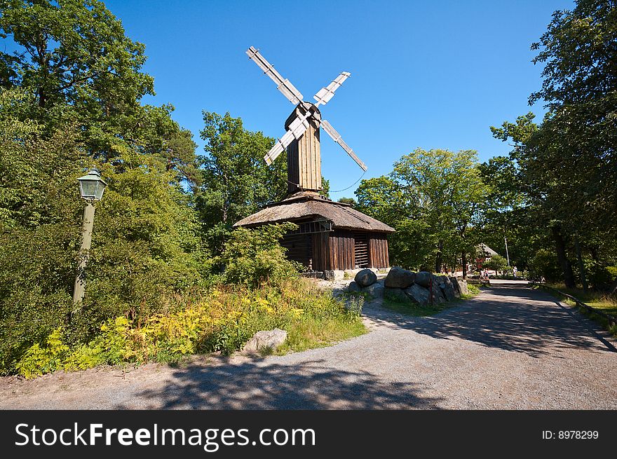 Old wooden windmill in scandinavian skansen with perfect blue sky