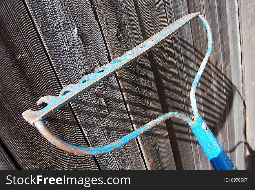 Garden rake leaning against the wood fencing