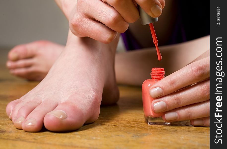 Woman applying nail polish on toe nails. Woman applying nail polish on toe nails