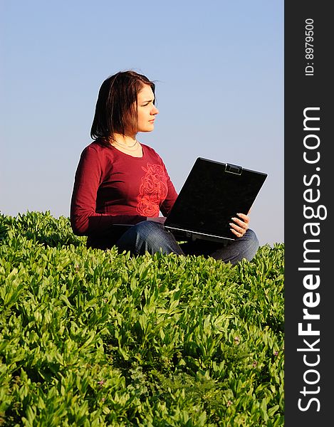 The beautiful girl with the laptop in the field. The beautiful girl with the laptop in the field