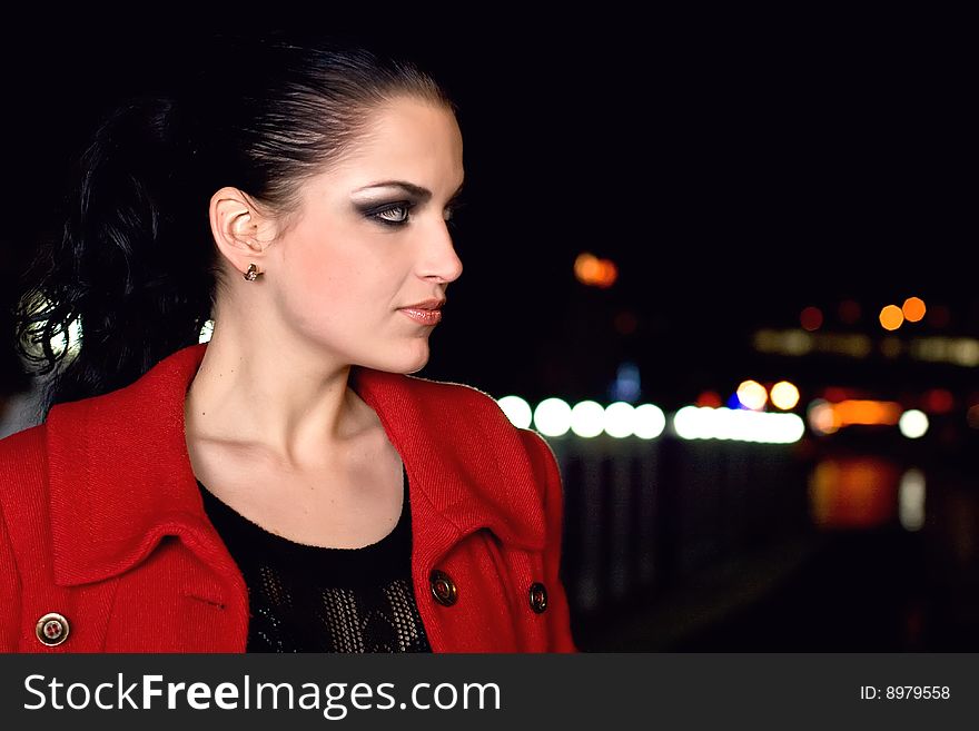 Young beautiful brunette in a coat walks on a night city. New photos every week. Young beautiful brunette in a coat walks on a night city. New photos every week