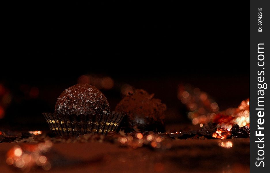Some chocolate truffles on dark background.