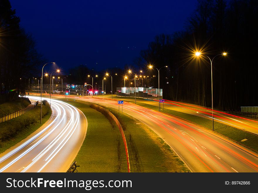 Blur of headlights and taillights on freeway illuminated with streetlamps at night. Blur of headlights and taillights on freeway illuminated with streetlamps at night.