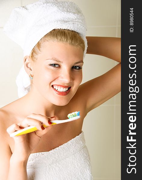 Happy young beautiful woman brushing her teeth in the bathroom. Happy young beautiful woman brushing her teeth in the bathroom