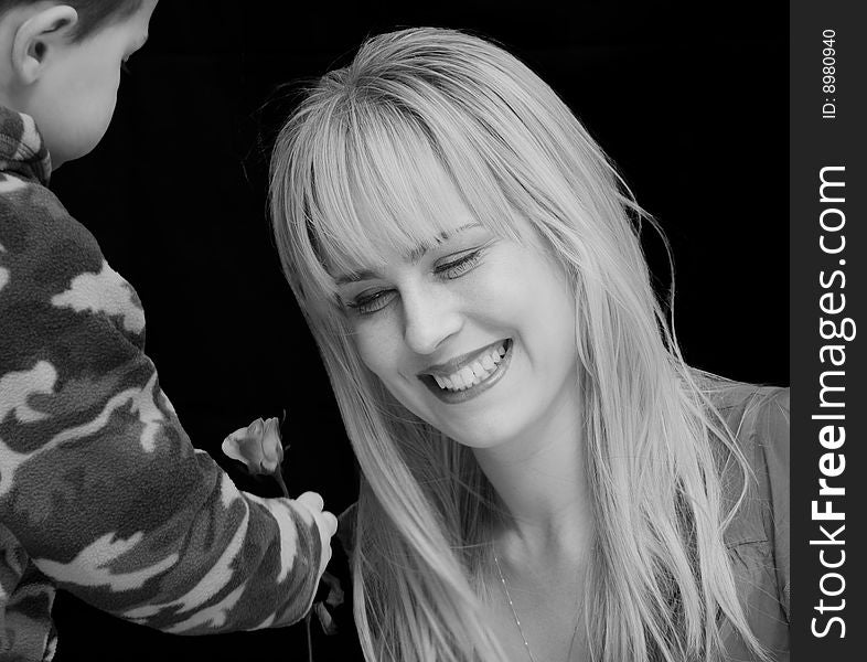 Little boy handing flower to a beautiful woman