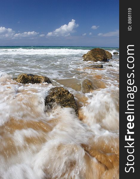 A wave breaking on a beach on a tropical island. A wave breaking on a beach on a tropical island.