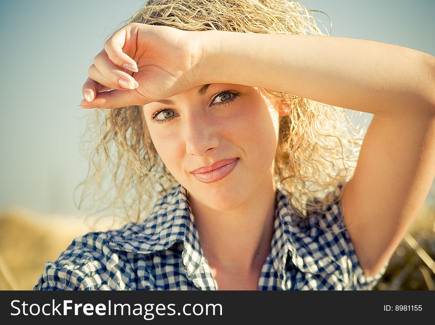 Close-up portrait of a beautiful country girl sitting on the haystack