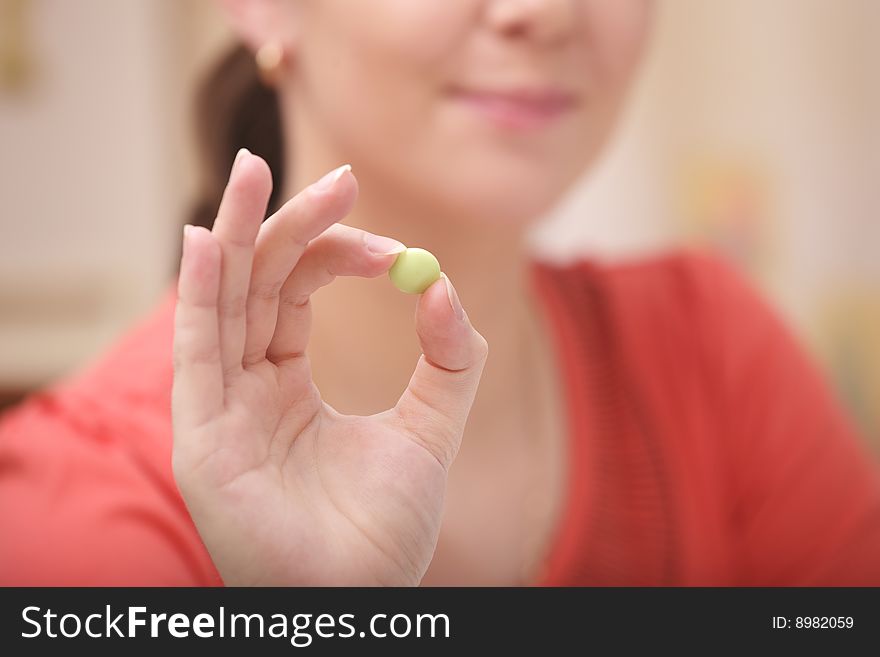 A photo of young girl with green vitamin. A photo of young girl with green vitamin