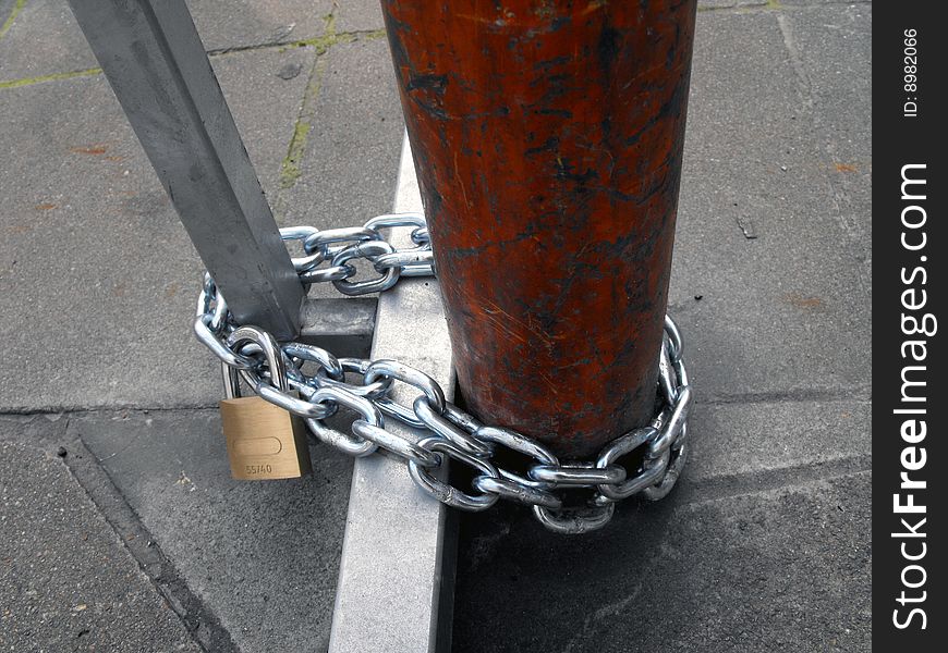 Chain and padlock closed to protect the steel of an object on street. Chain and padlock closed to protect the steel of an object on street.