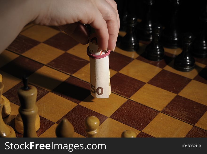 Chess on chessboard with banknote participating in a game. Chess on chessboard with banknote participating in a game