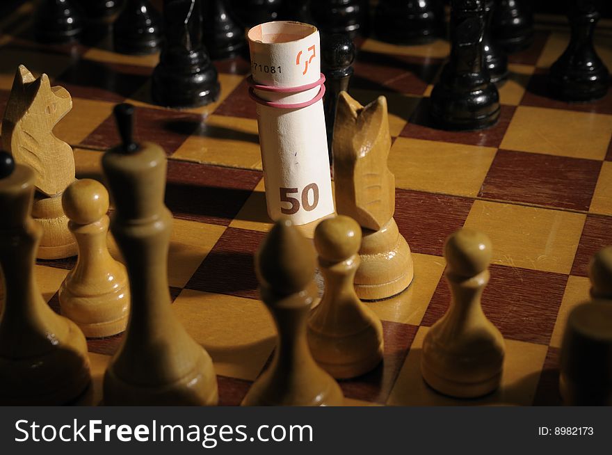 Chess on chessboard with banknote participating in a game. Chess on chessboard with banknote participating in a game