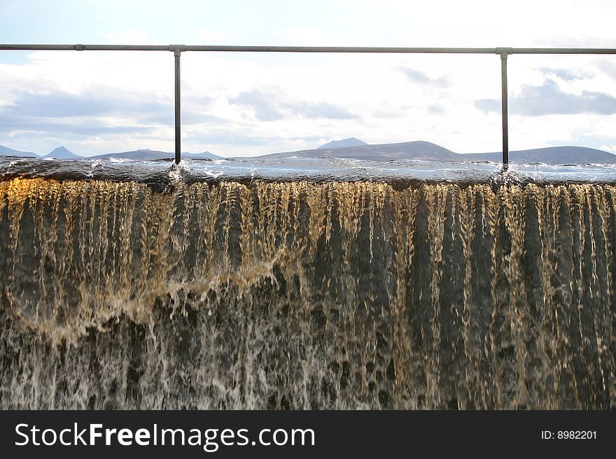 A reservoir flooding with peat stained water mountains in the background. A reservoir flooding with peat stained water mountains in the background.