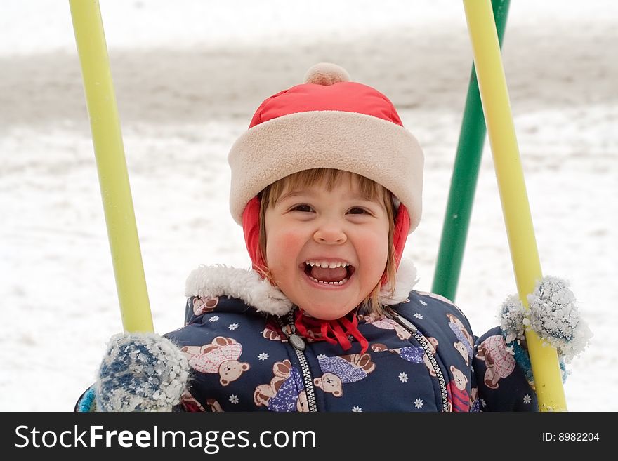 Child is playing in colorful swing at the playground. Child is playing in colorful swing at the playground