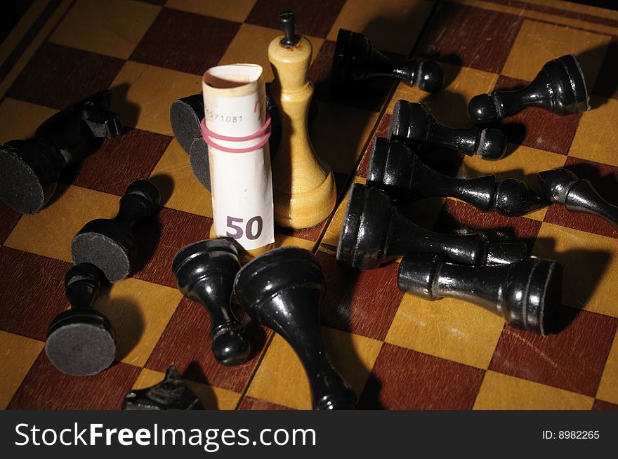 Chess on chessboard with banknote participating in a game. Chess on chessboard with banknote participating in a game