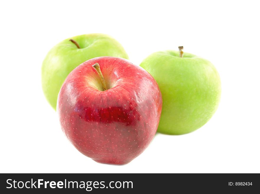 One red and two green apples on a white background. One red and two green apples on a white background.
