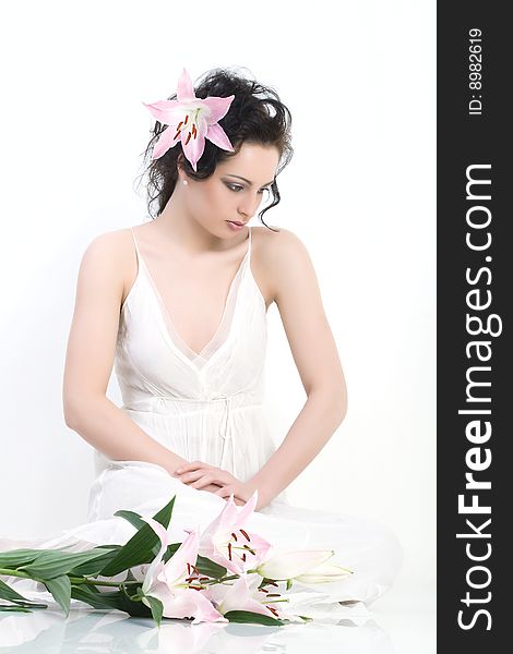 Beautiful woman sits in the white dress with the pink flowers. Beautiful woman sits in the white dress with the pink flowers.