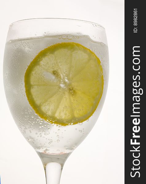 a glass of ice cold lemon drink with ice cubes. a glass of ice cold lemon drink with ice cubes