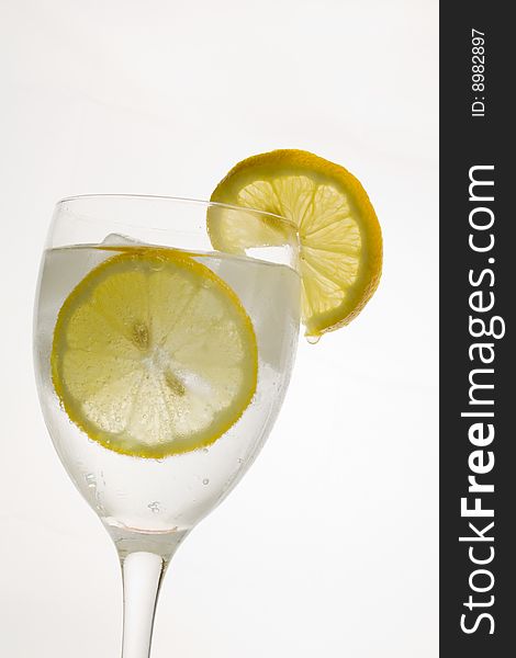 A glass of ice cold lemon drink with ice cubes. A glass of ice cold lemon drink with ice cubes