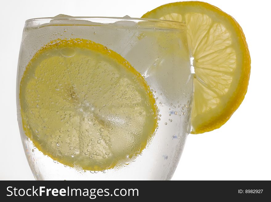 A glass of ice cold lemon drink with ice cubes. A glass of ice cold lemon drink with ice cubes