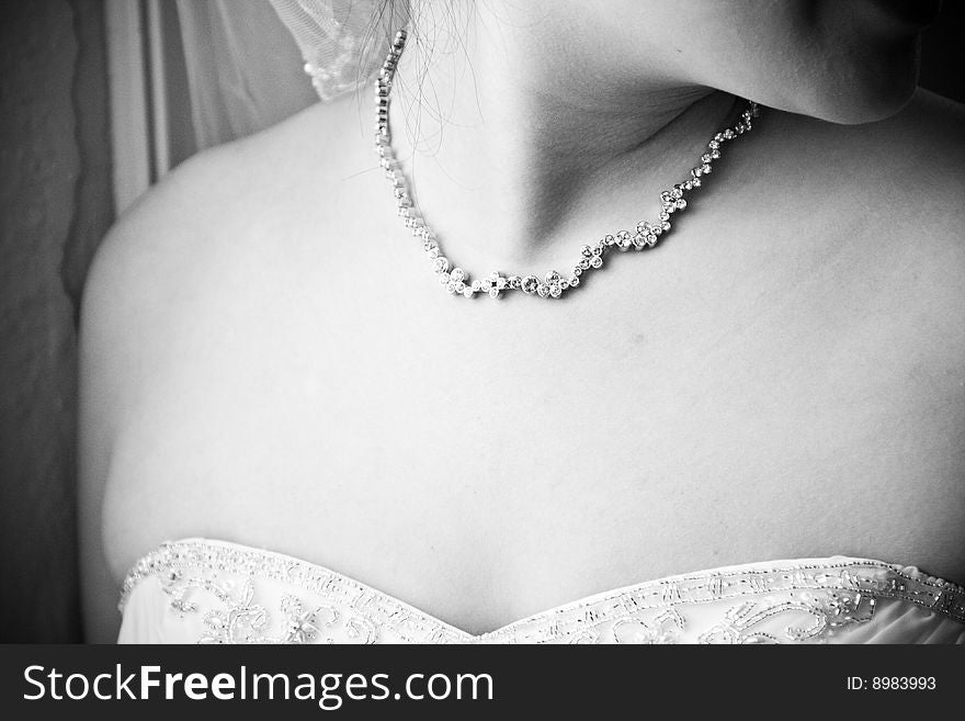 Bride wearing necklace before ceremony
