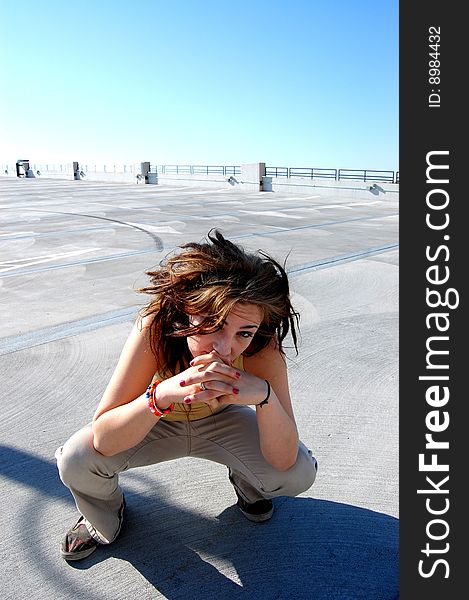 Teenage girl crouching down in the sunlight