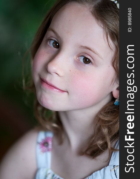 A pretty young blonde girl with a pensive expression and wearing a flowered sun dress. A pretty young blonde girl with a pensive expression and wearing a flowered sun dress