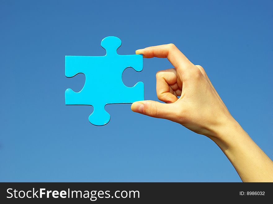 Puzzle in hand isolated on sky background