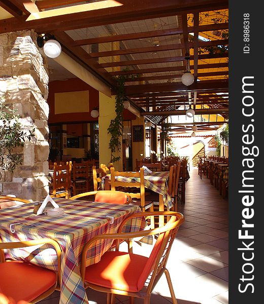 Cover terrace of greek taverna with chairs and tables